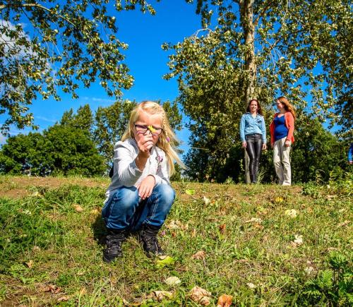 Kind in het gras met mensen op de achtergrond